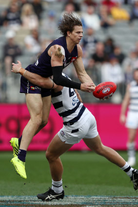 Nat Fyfe of the Dockers is tackled by Tom Hawkins of the Cats .