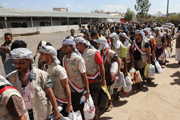 Houthi prisoners freed in Mokha carrying their belongings as they arrive in Sanaa on September 12.