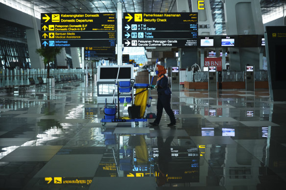 A cleaner walks through the nearly empty Soekarno-Hatta International Airport in Jakarta, Indonesia.