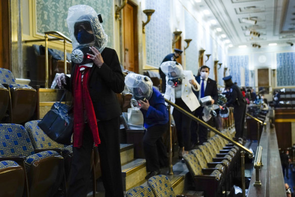 People shelter in the House of Representatives gallery as protesters try to break into the chamber at the US Capitol.