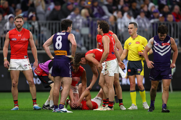 Teammates and medical staff check on Brandon Zerk-Thatcher after a collision with Essendon teammate Sam Durham.