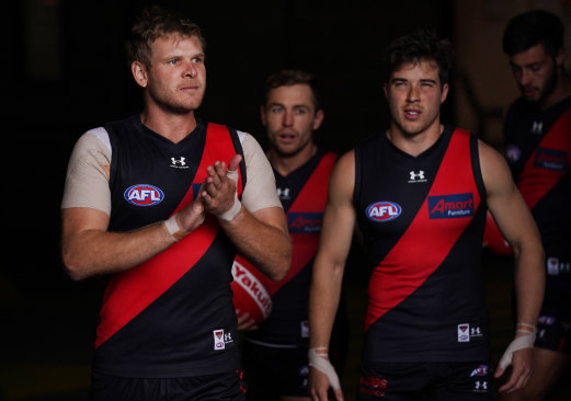 Michael Hurley (left) leads the Bombers out for their opening-round clash with Fremantle.
