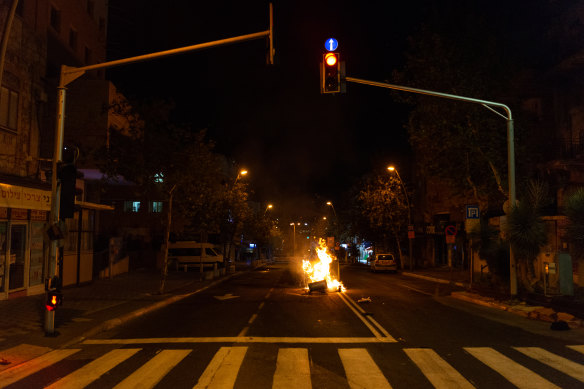 A fire started by rioters in the middle of the street in the Hadar suburb of Haifa, Israel. 