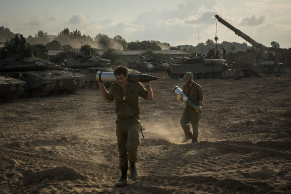 Israeli soldiers load tank shells as their unit massed in Be’eri, near the border with the Gaza Strip on Saturday,