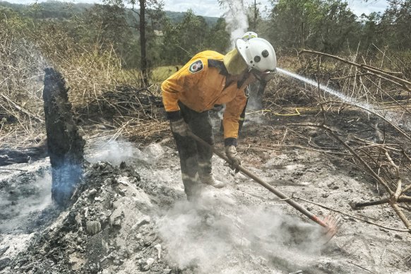 Crews start to “black out” using a rake/hoe tool called a McLeod to lift wood and glowing embers, crushing the heat into the dirt.