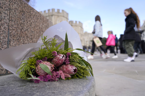 Flowers are left outside Windsor Castle after Princess Catherine’s revelation.