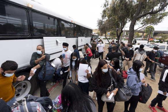 A group of migrants seeking asylum look for transportation options after being processed and released in San Diego.