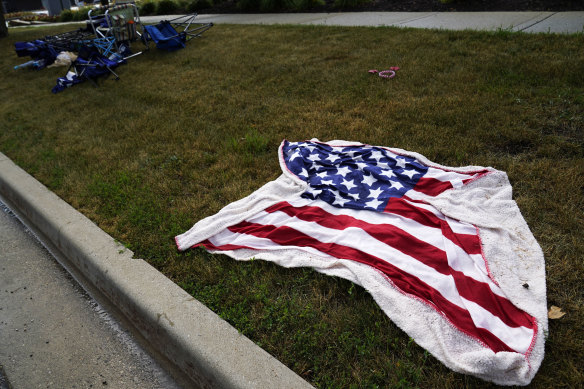 Empty chairs and an American flag blanket lie abandoned on the ground after a mass shooting at the Highland Park Fourth of July parade in downtown Highland Park, a Chicago suburb, on July 4.