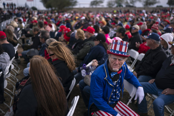 A supporter dressed as Uncle Sam sits among the crowd at a rally for former president Donald Trump in Arizona.