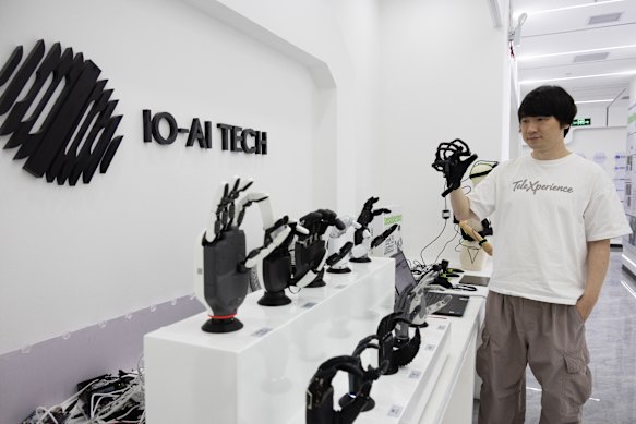 IO-AI Tech founder Xiangyu Chen with the company’s exoskeleton glove that can be used to control humanoid hands. 