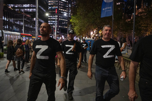 Men wearing Russian Z shirts, championing the invasion of Ukraine, arrive at Town Hall on Friday night.