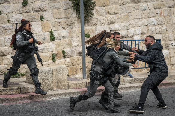 Israeli security officers scuffle with a Palestinian man at a checkpoint near the Al-Aqsa Mosque in Jerusalem last month.