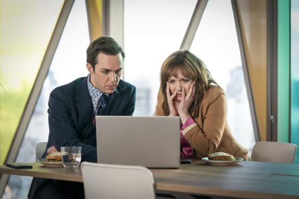 Rowan Witt and Katherine Parkinson consulting the database in <i>Spreadsheet</i>.