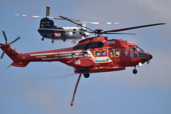 A Kestrel Aviation Super Puma Helitak 349 firebombing helicopter in front of a Coulson Aviation CH-47D Chinook helicopter in Victoria.