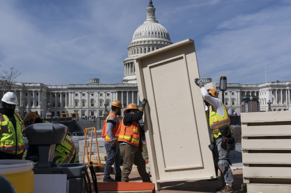 Workmen construct and erect panels on the East side of the Capitol in Washington. 