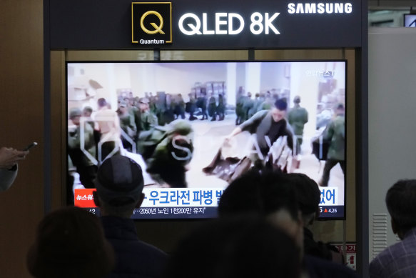 A TV screen shows an image of soldiers believed to be from North Korea stand in line to receive supplies from Russia.