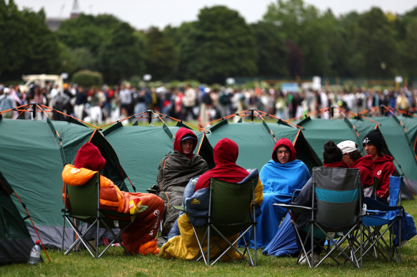 Spectators queue while outside their tents at Wimbledon Park.