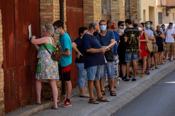 People queue to be tested for COVID-19 in Barcelona, Spain.