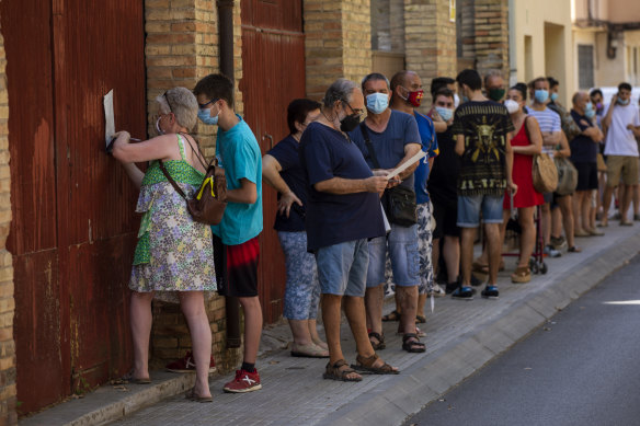 People queue to be tested for COVID-19 in Barcelona, Spain.