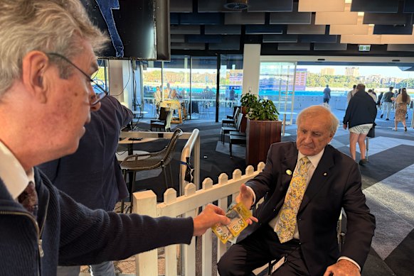 Bookmaker Robbie Waterhouse hands over the election bet cash to former Labor minister John Brown.