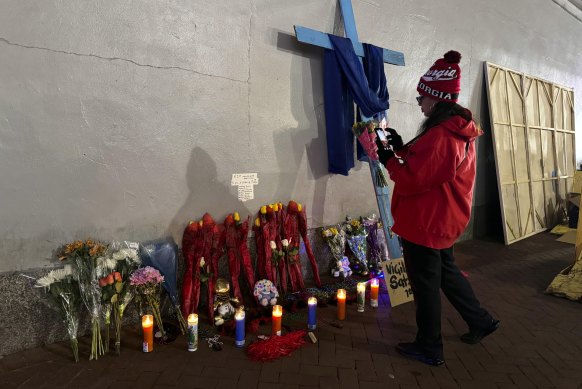 A Georgia football fan takes a photo of a memorial to victims of the Bourbon Street attack after the area reopened.