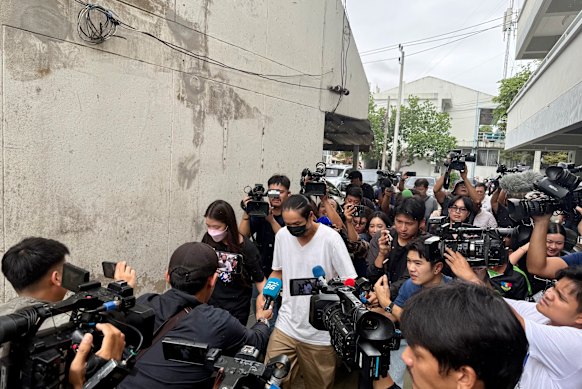 The Thai shooter’s father, in white, leaving the police station on Sunday.