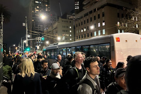 Commuters queue for replacement buses at Parliament on Monday evening.