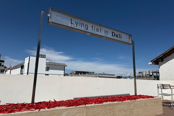 Chillies dry in the sun on the rooftop of a hotel in Dali that has tapped into a “lying flat” aesthetic.