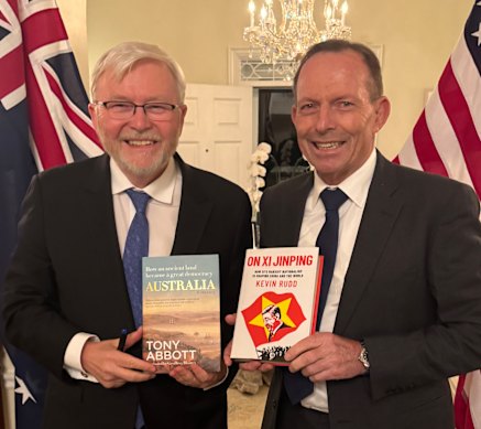 Former prime ministers Tony Abbott and Kevin Rudd brandishing each other’s books while in Washington.