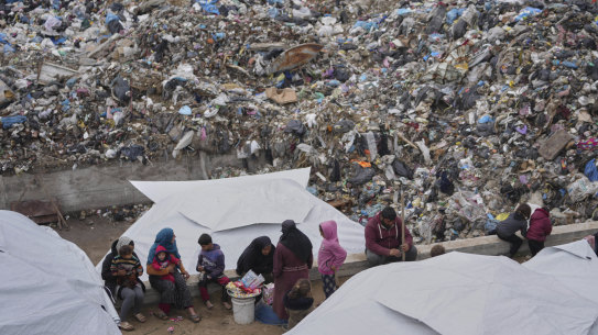 Palestinians displaced by the Israeli air and ground offensive it in a makeshift tent camp inside a landfill in central Gaza Strip on Friday.