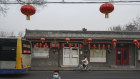 A Chinese boy wears a protective mask outside closed shops and restaurants in what is usually a busy tourist street in Beijing during the Chinese New Year holiday.