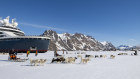 Southeast Greenland, Kulusuk. Dog sledding with Charcot in the distance