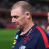 Demons coach Simon Goodwin leaves the field after his side coughed up a near four-goal lead to lose to the Lions.