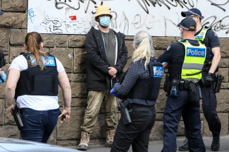 Police speaking to people in Melbourneâs CBD yesterday. 