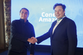Brazil’s President Jair Bolsonaro, left, and Elon Musk shake hands during a meeting in Porto Feliz, Brazil.