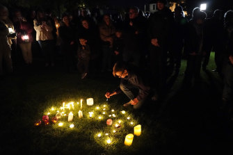 People gather and light candles at a vigil in Leigh-on-Sea, England on  Saturday to honour British Conservative MP Sir David Amess who died after being stabbed on Friday. 