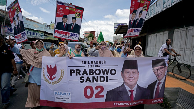 Supporters gesture as they carry a banner featuring Prabowo Subianto, presidential candidate, left, and Sandiaga Uno, vice-presidential candidate, during a campaign in Klaten, Yogyakarta, Indonesia, on  March 23.