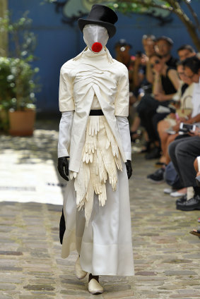 Wearing spookily pre-emptive mask and gloves, a model walks the runway during Paris Fashion Week in June 2019.