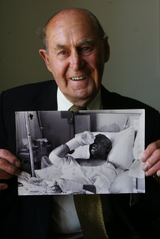 Ranald Webster in 2008 with a picture of himself recovering from Ash Wednesday burns.