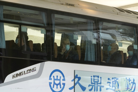 Members from the World Health Organisation team leave hotel quarantine on a bus.