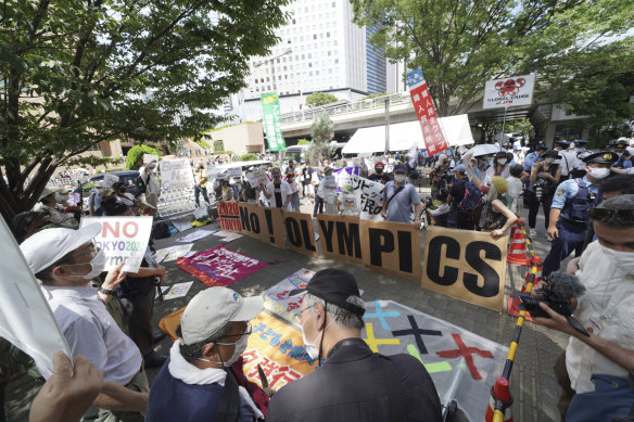 Anti-Olympics protesters hold signs during a rally near the Tokyo Metropolitan Government complex where the final Olympic torch relay event took place in Tokyo on Friday.