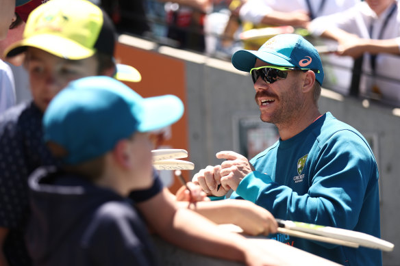 David Warner signs autographs for fans at the Adelaide Oval on Friday.