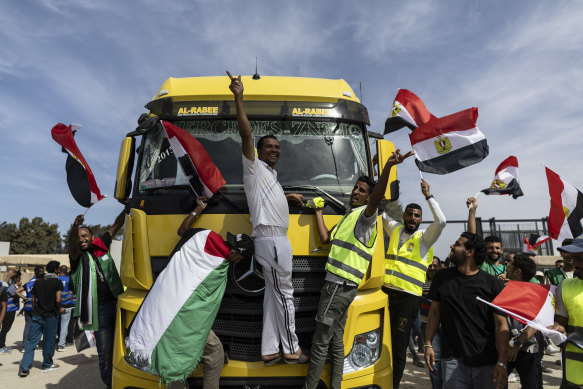 Volunteers and NGO staff celebrate after unloading aid supplies and returning to the Egyptian side of border near Rafah, in North Sinai, Egypt.