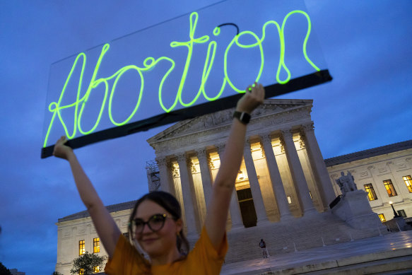 Hope Neyer marks the first anniversary of the Supreme Court’s decision that overturned Roe v Wade, by displaying a neon sign in support of abortion access in front of the US Supreme Court.