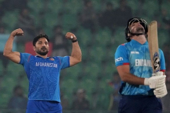 Afghanistan’s Gulbadin Naib, left, celebrates after taking the wicket of England’s Liam Livingstone, right, during the ICC Champions Trophy cricket match between Afghanistan and England in Lahore, Pakistan.
