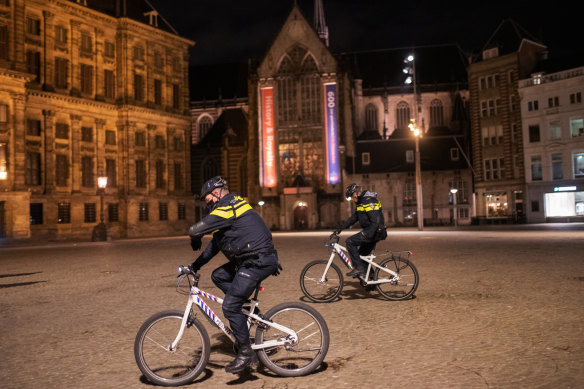 Police officers patrol a street in Amsterdam, Netherlands, where an emergency nighttime curfew has been introduced for the first time since World War II. 