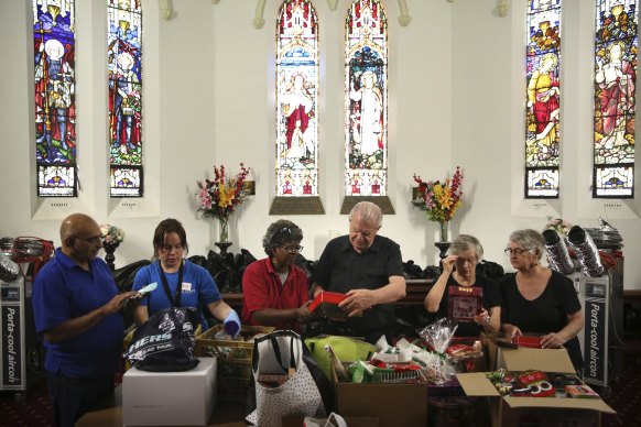Reverend Bill Crews and volunteers of the Exodus Foundation sort through Christmas donations at their Ashfield parish prior to Chrismas Day. 