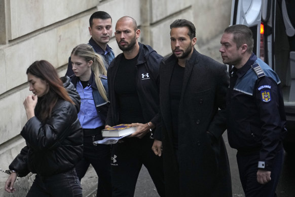 Andrew Tate, third right, and his brother Tristan, second right, are brought by police officers to the Court of Appeal.