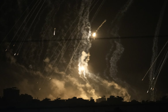 Дым и сигнальные ракеты поднимаются над городом Газа во время израильского удара по сектору Газа, вид с юга Израиля.