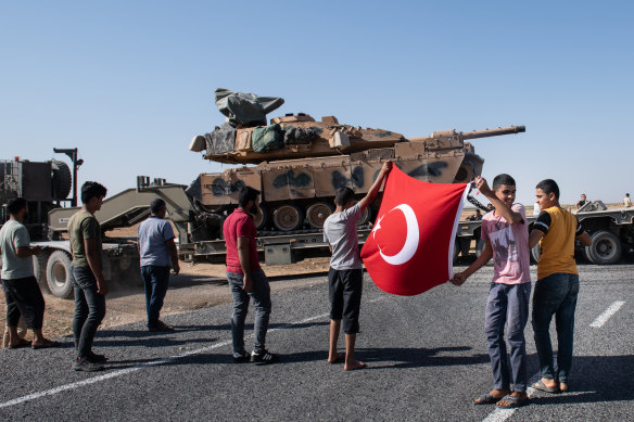 People show their support for the Turkish military near Ackakale as tanks move into Syria.